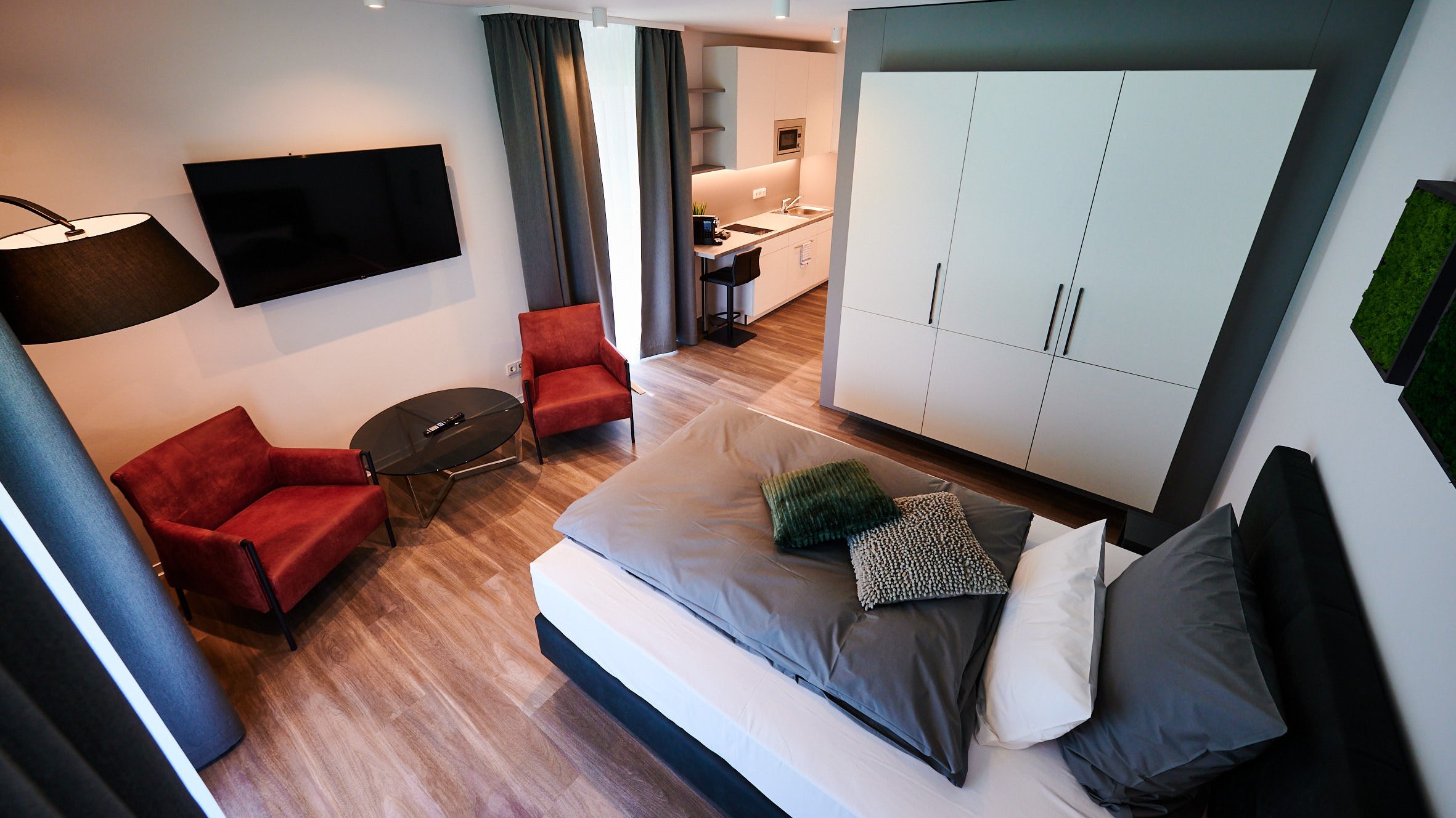 Komfortables Schlafzimmer mit roter Sitzecke und TV