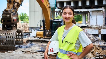 Auszubildende vor Baumaschinen im Außeneinsatz