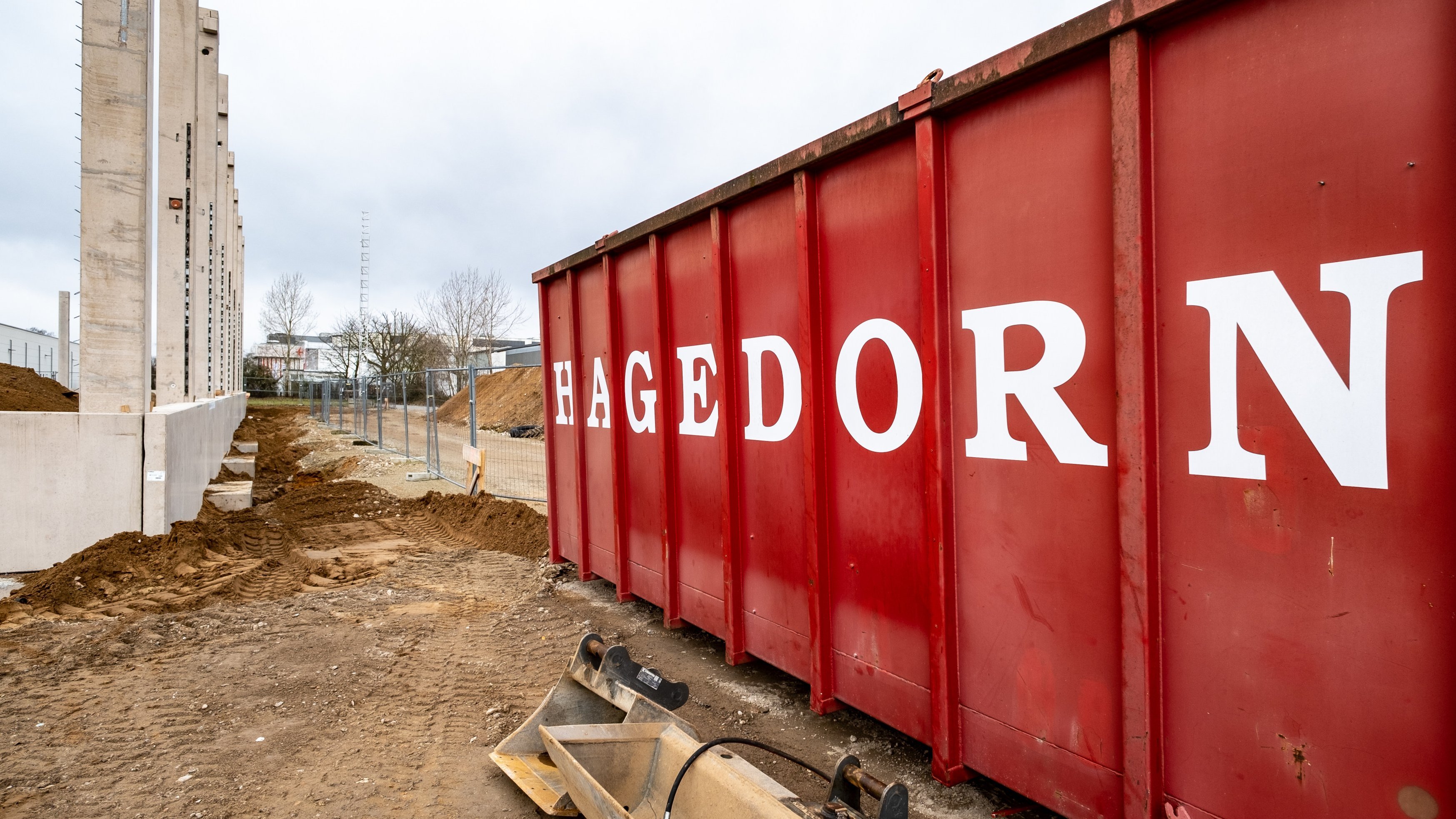 Großer roter Lagercontainer bei Bauarbeiten.