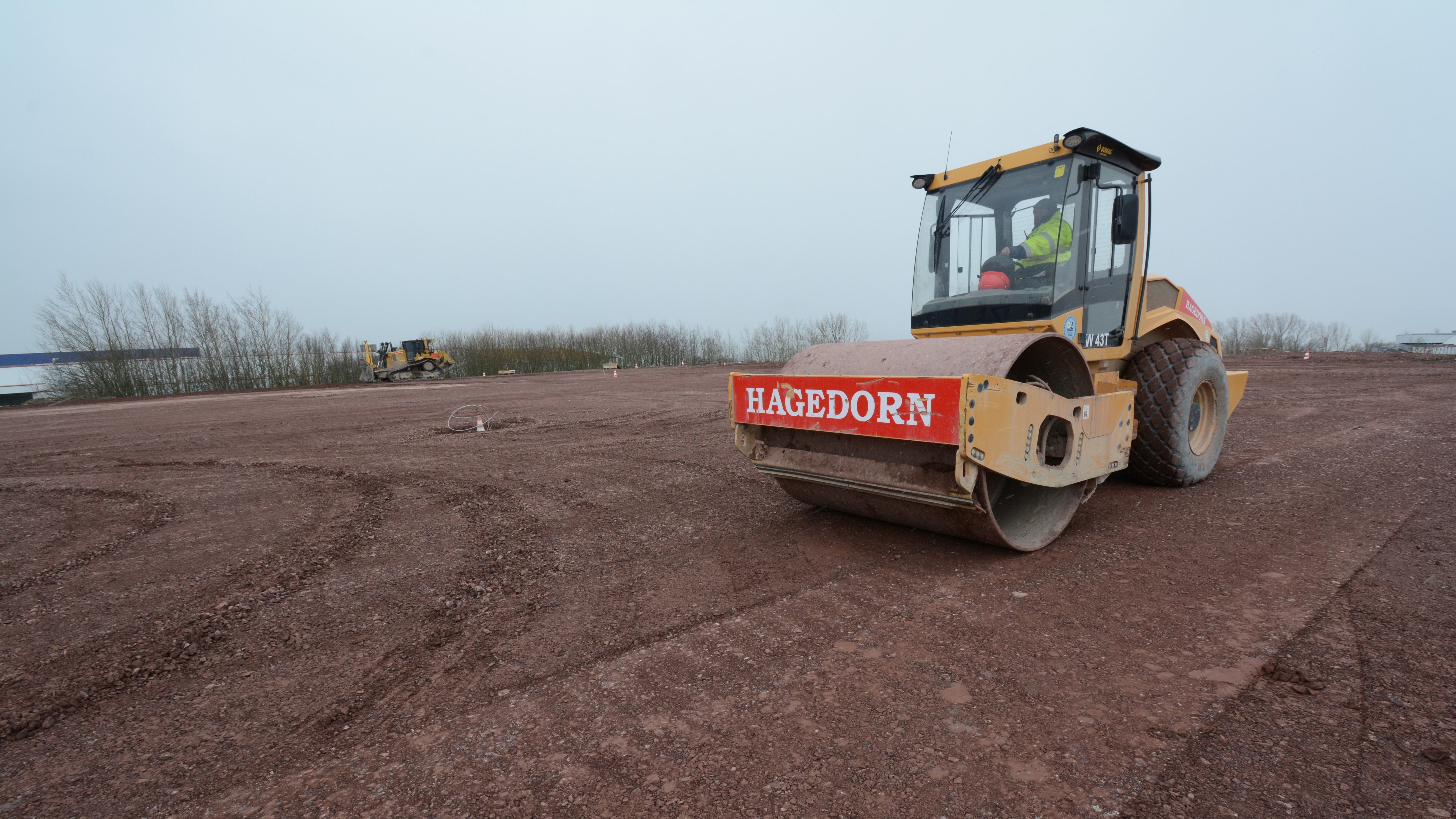 Walzenfahrzeug von Hagedorn verdichtet Boden auf Baustelle.