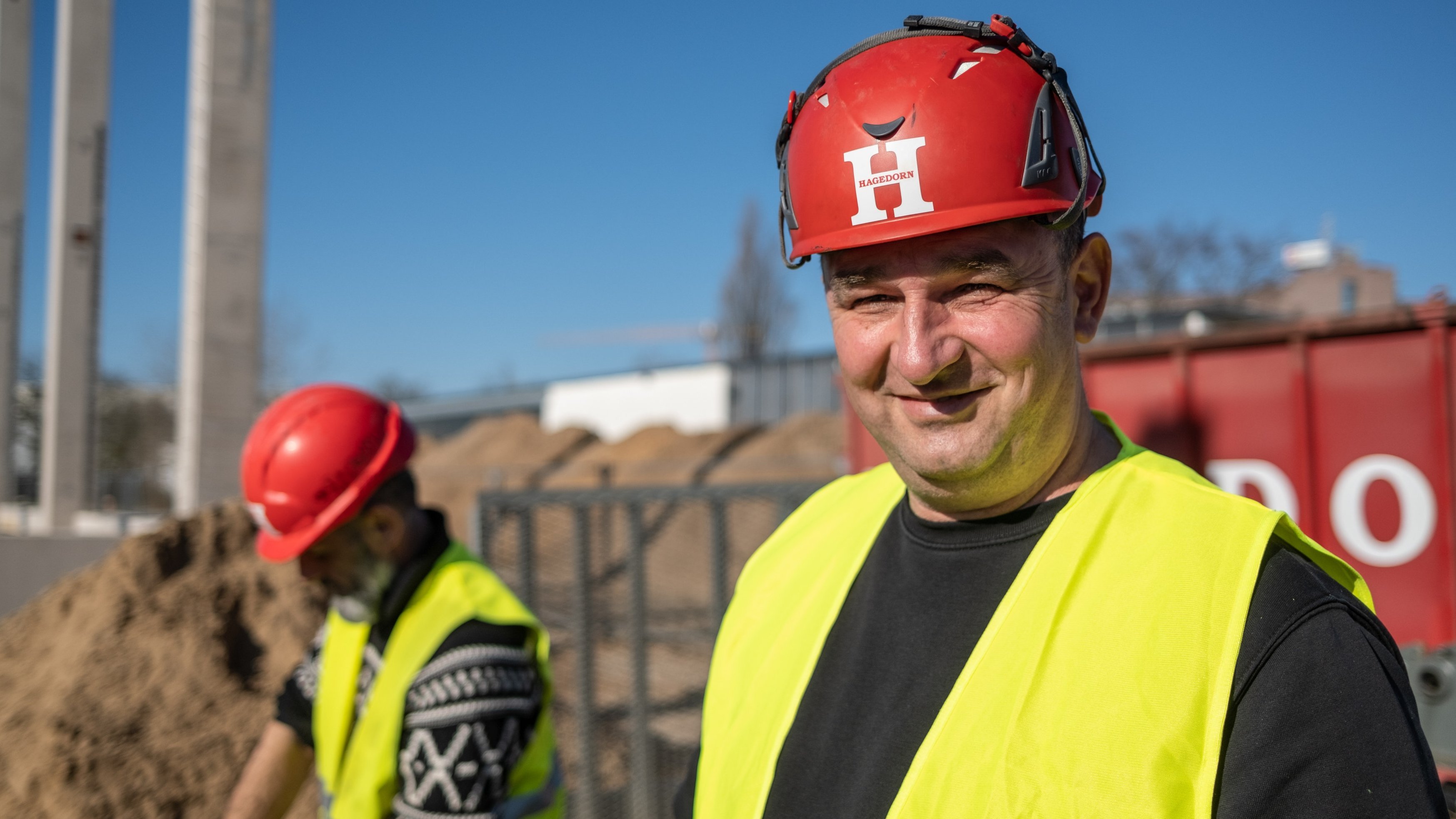 Porträt eines Bauarbeiters mit rotem Helm.
