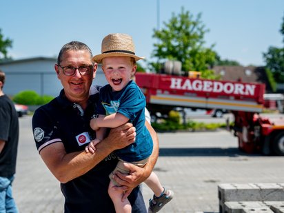 Mann und Kind lachen vor LKW