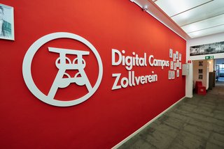 Roter Wandhintergrund mit Digital Campus Zollverein Logo