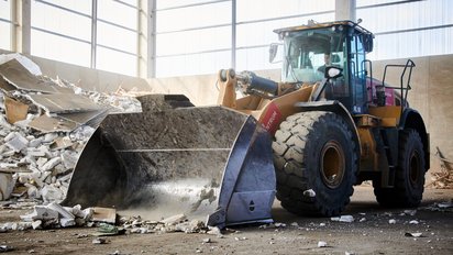 Frontlader bewegt Bauschutt in Halle