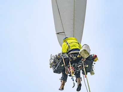 Techniker sichert sich an Windturbinenflügel