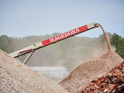 Förderband transportiert Schutt auf Baustelle