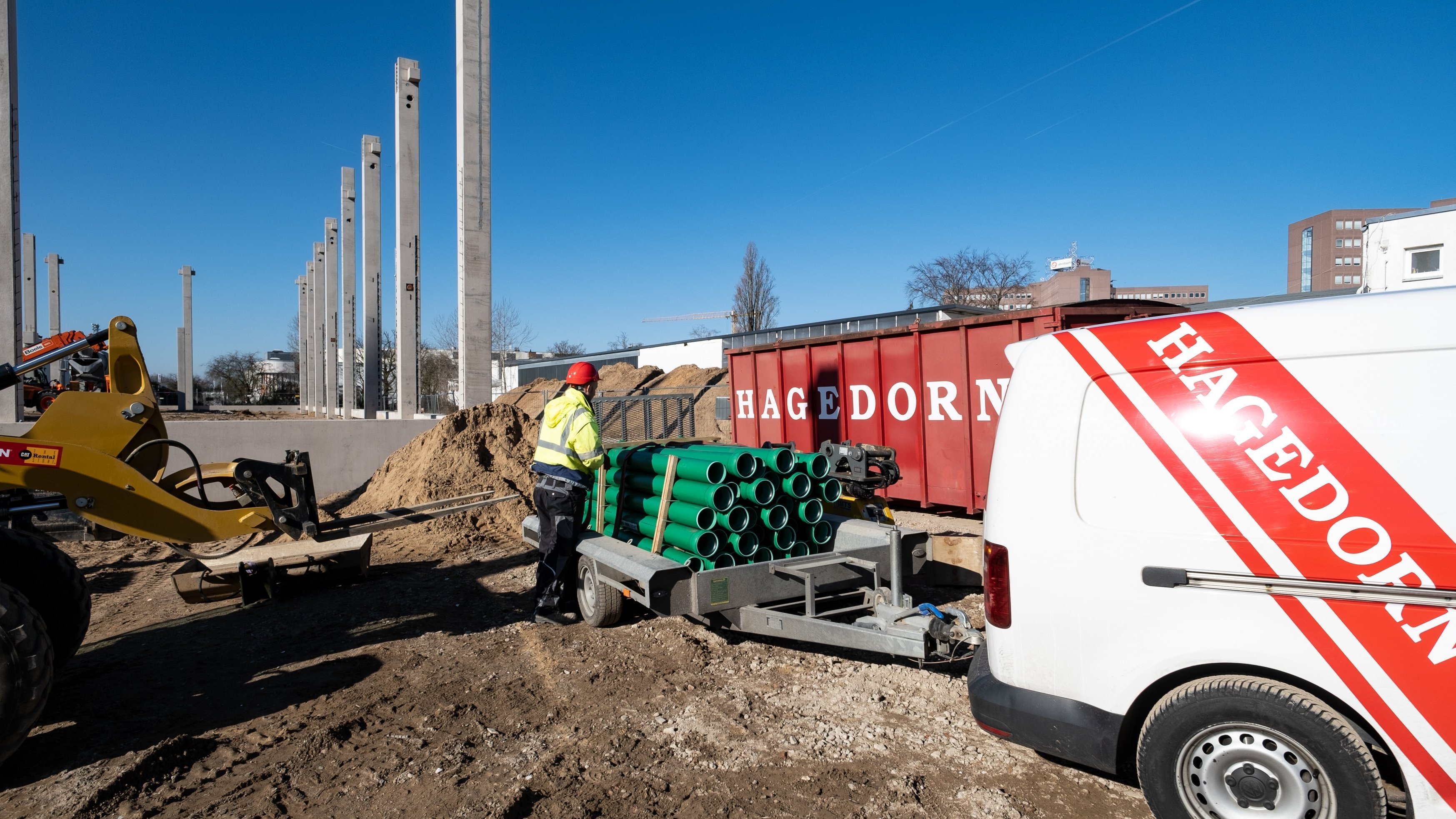 Baustellenfahrzeug neben Hagedorn-Container.