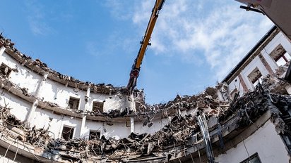 Hochreichender Bagger bei der Abbrucharbeit, Sanierungsprojekt.