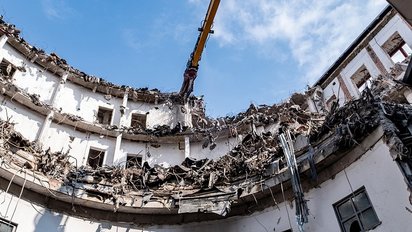 Hochreichender Bagger bei der Abbrucharbeit, Sanierungsprojekt.